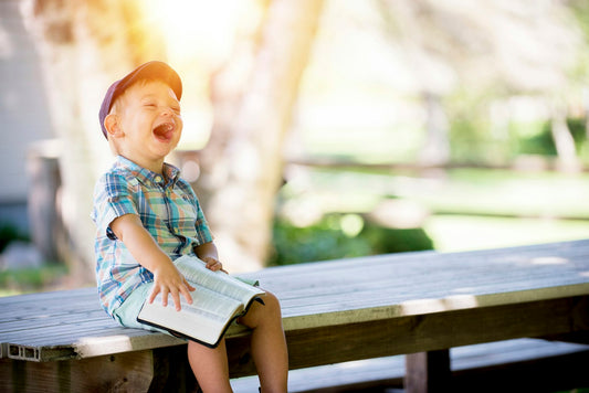 Immagine di un bambino che legge all'aperto