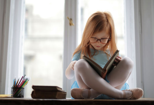 Immagine di una bambina che legge un libro